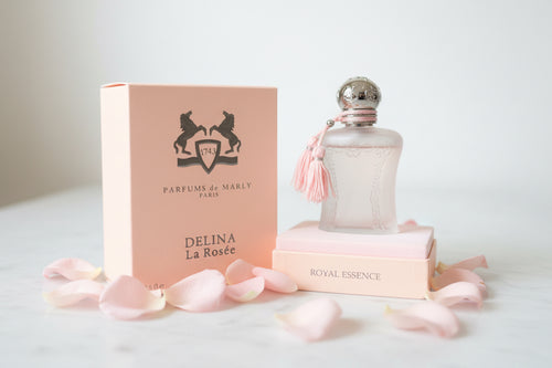 Parfums de Marly Delina La Rosée perfume bottle and packaging on a textured surface